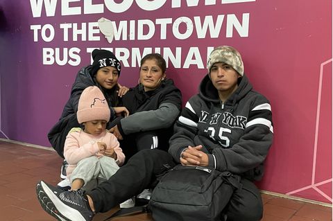 Gustavo (r.) sitzt mit seiner Frau Karina (M) und ihren beiden Töchtern am Busbahnhof in New York. Die Familie aus Ecuador hofft wie viele andere auf ein besseres Leben in den USA.