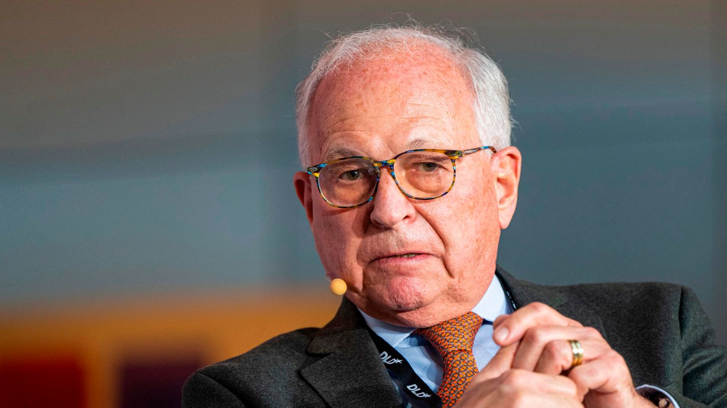 Wolfgang Ischinger sitzt in Anzug und Krawatte auf einem Podium und spricht, während er mit beiden Händen gestikuliert