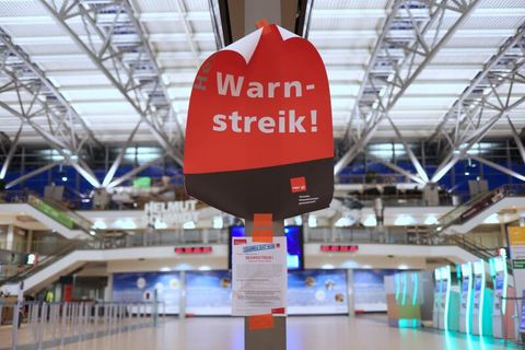 Ein Plakat mit dem Text ·Warnstreik!· hängt im menschenleeren Terminal 2 im Flughafen Hamburg