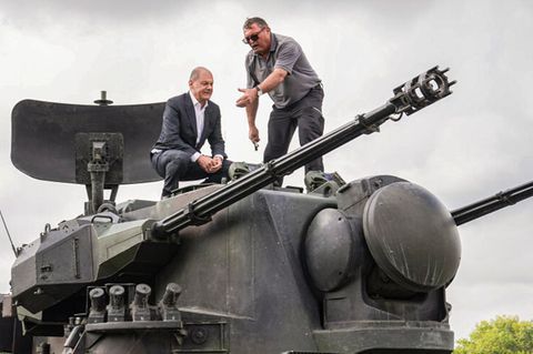 Bundeskanzler Olaf Scholz klettert auf einen Gepard-Panzer.