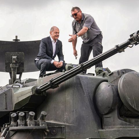 Bundeskanzler Olaf Scholz klettert auf einen Gepard-Panzer.