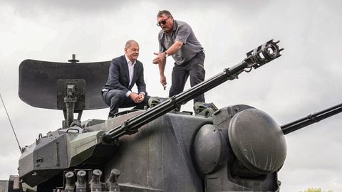 Bundeskanzler Olaf Scholz klettert auf einen Gepard-Panzer.