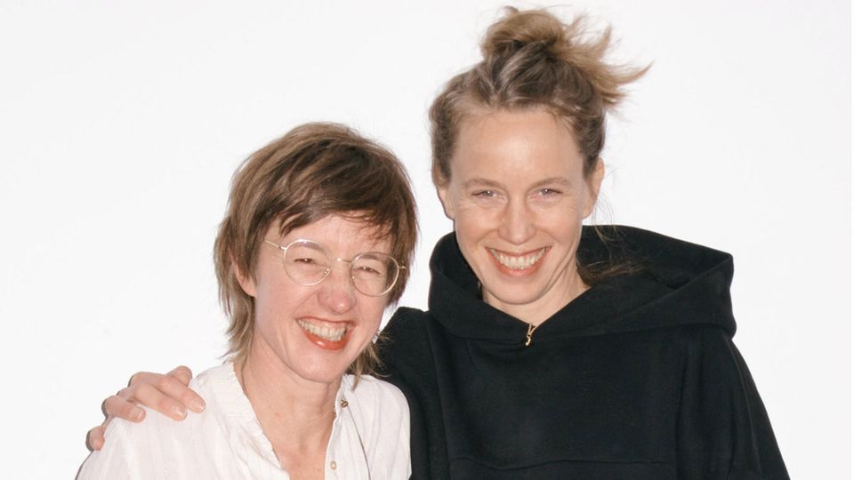 Marietta Schwarz (l.) und Katja Bigalke stehen vor einer Wand und lächeln
