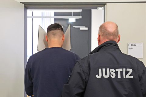 Der Angeklagte (l.) wird mit verdecktem Gesicht in den Gerichtssaal geführt. Jetzt geht er lebenslänglich in Gefänginis