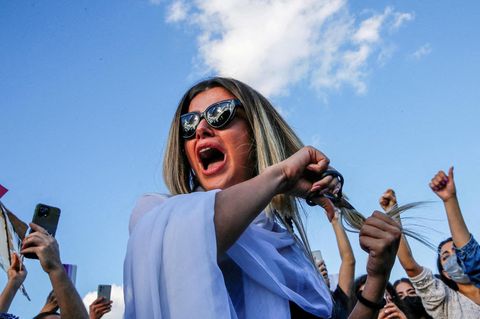 Frau schneidet ihre Haare ab