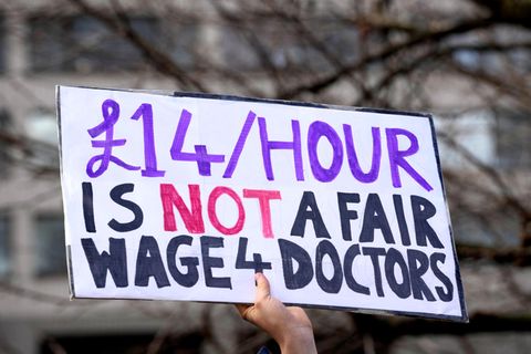 Ärzte des britischen Gesundheitssystems streiken, auf diesem Schild steht: "14 Pfund ist kein fairer Stundenlohn für Ärzte".