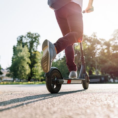 Ein Junge fährt E-Scooter im Park