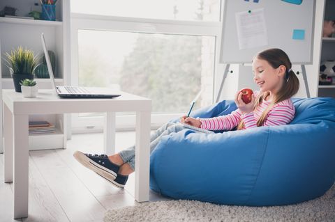 Sitzsack für Kinder: Mädchen liegt auf einem bunten Sitzsack