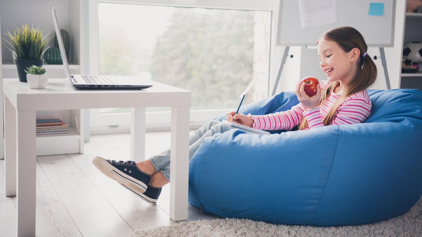 Sitzsack für Kinder: Mädchen liegt auf einem bunten Sitzsack