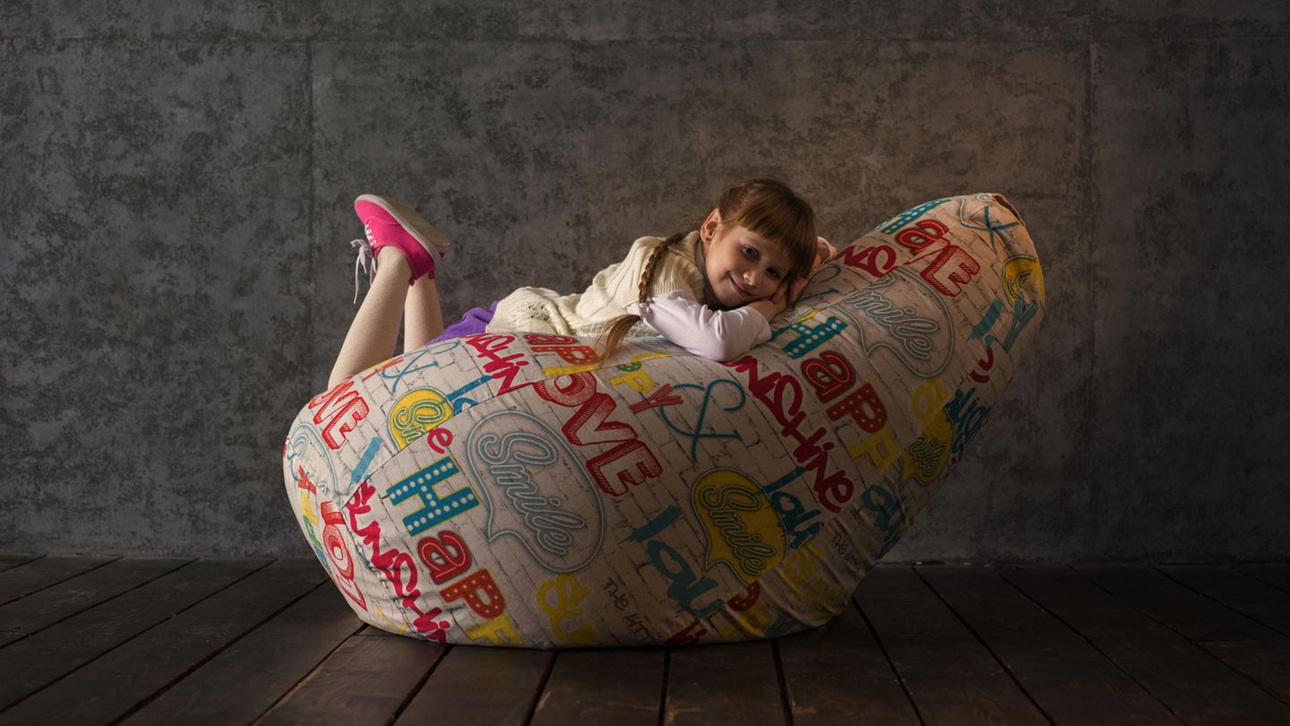Sitzsack für Kinder: Mädchen liegt auf einem bunten Sitzsack
