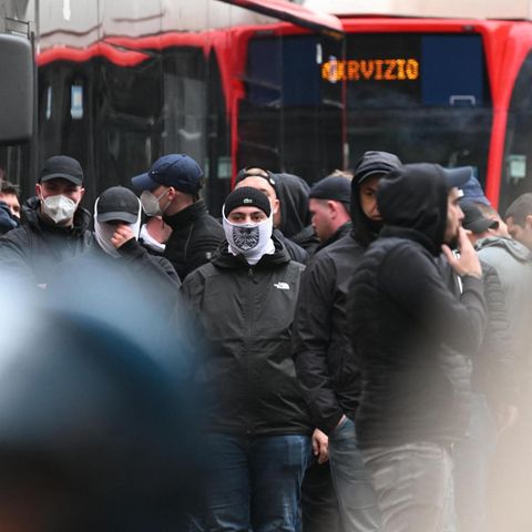 Eintracht Frankfurt stehen zwischen italienischer Bereitschaftspolizei und rot lackierten Bussen