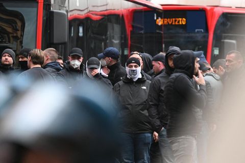 Eintracht Frankfurt stehen zwischen italienischer Bereitschaftspolizei und rot lackierten Bussen