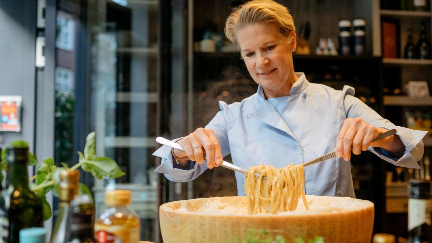 Cornelia Poletto wendet Pasta in einem riesigen Parmesanlaib