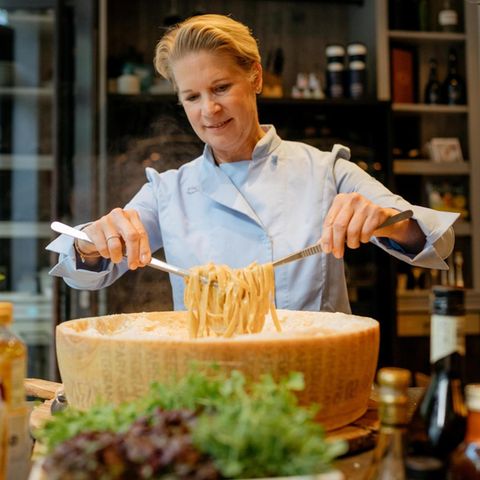Cornelia Poletto wendet Pasta in einem riesigen Parmesanlaib