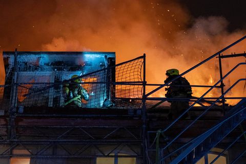 Zwei Feuerwehrleute auf brennendem Haus