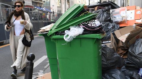 In Paris spaziert eine Frau an einem der unzähligen Müllberge vorbei