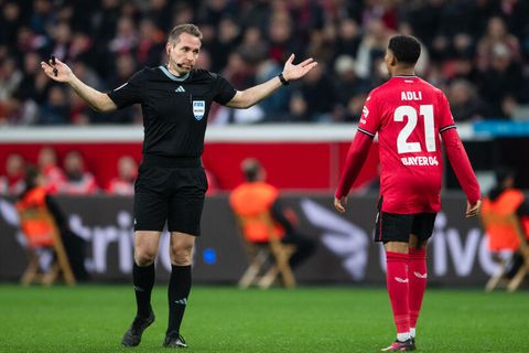 Schiedsrichter Tobias Stieler gestikuliert neben Leverkusens Amine Adli