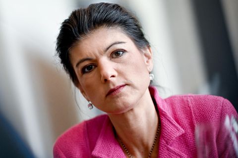 Die Linken-Politikerin Sahra Wagenknecht trägt einen pinken Blazer und blickt starr in die Kamera