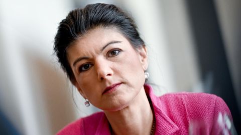 Die Linken-Politikerin Sahra Wagenknecht trägt einen pinken Blazer und blickt starr in die Kamera