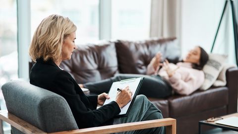 Coaching-Szene: Eine Frau liegt auf einem Sofa und redet, eine andere macht sich Notizen