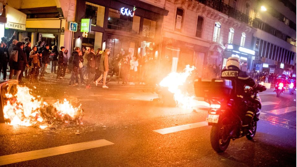 Ein Feuer brennt auf einer Straße in Paris nach Protesten gegen die umstrittene Rentenreform