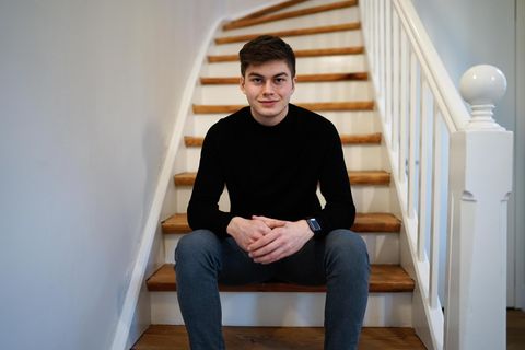 Schüler Liam Kastner sitzt in einem schwarzen Oberteil auf einer Treppe
