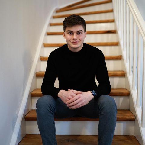 Schüler Liam Kastner sitzt in einem schwarzen Oberteil auf einer Treppe