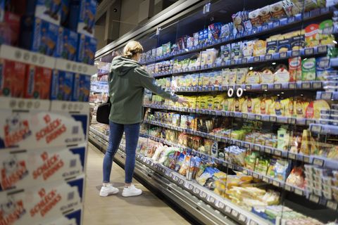Frau steht am Kühlregal im Superamarkt