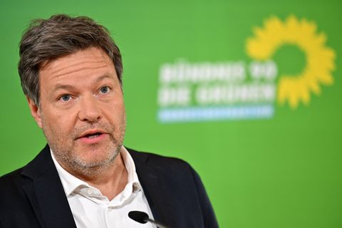 Robert Habeck spricht vor einer grünen Wand mit Logo von Bündnis 90/Die Grünen in ein Mikrofon