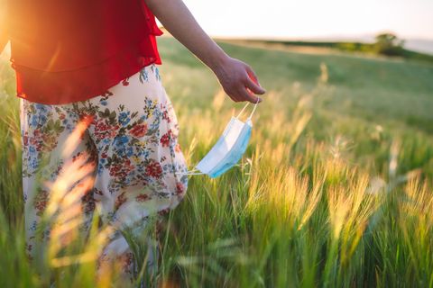 Allergiesaison: Frau läuft mit Maske über ein Feld