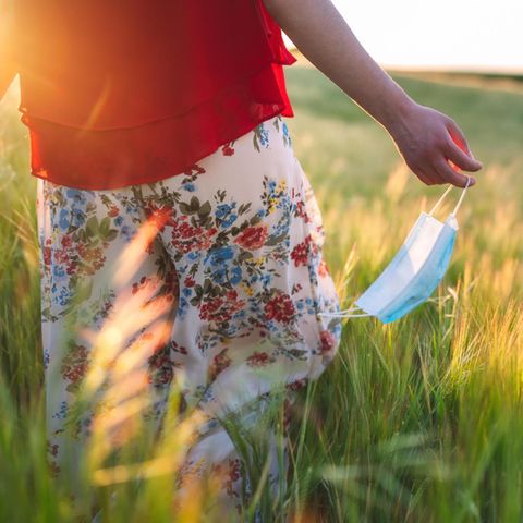 Allergiesaison: Frau läuft mit Maske über ein Feld