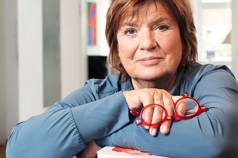 Christine Westermann lehnt auf einem Bücherstapel
