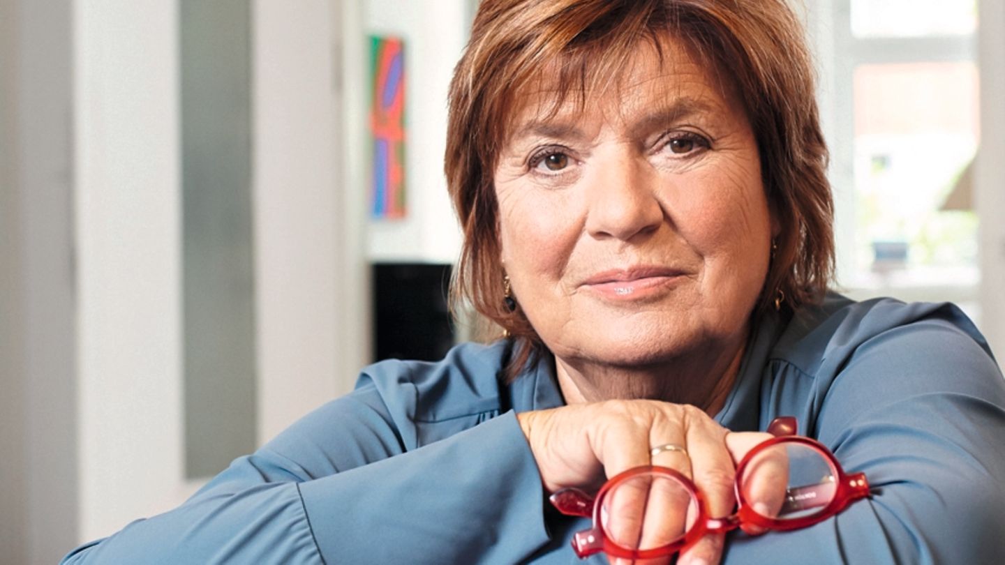 Christine Westermann lehnt auf einem Bücherstapel
