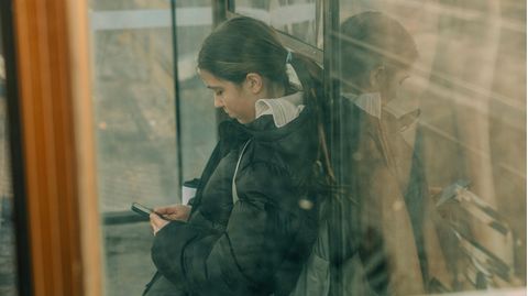Eine Jugendliche schaut auf ihr Handy