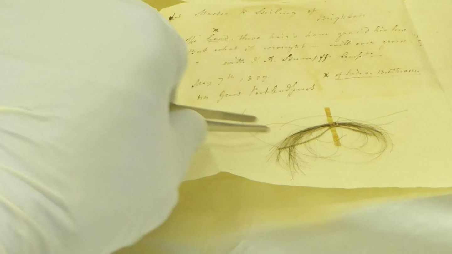Haare von Ludwig van Beethoven kleben auf gelblichem Briefpapier mit einer verblichenen Handschrift