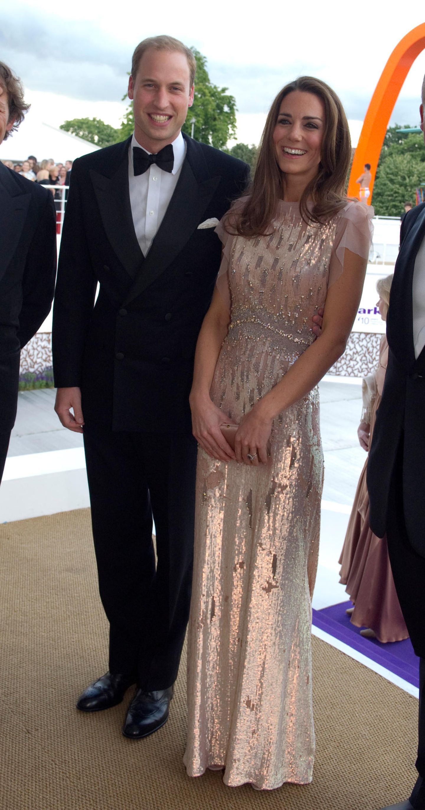 Künftige Königin: Einen guten Monat nach ihrer Traumhochzeit absolvierte das Prinzenpaar seinen ersten Termin als Ehepaar. Zu einem Charity-Dinner Anfang Juni 2011 erschienen William und Kate in festlichen Outfits. Er in einem Anzug mit Fliege und sie in einem roséfarbenen Glitzertraum von Jenny Packham. Das Kleid entstammte der Sommer-Kollektion des britischen Labels und kostete damals mehr als 3000 Euro. Zu dem mit Swarovski-Steinen besetzten Dress kombinierte Kate LK-Bennett-Heels mit Schleife und eine Prada-Clutch. Einen guten Monat nach ihrer Traumhochzeit absolvierte das Prinzenpaar seinen ersten Termin als Ehepaar. Zu einem Charity-Dinner Anfang Juni 2011 erschienen William und Kate in festlichen Outfits. Er in einem Anzug mit Fliege und sie in einem roséfarbenen Glitzertraum von Jenny Packham. Das Kleid entstammte der Sommer-Kollektion des britischen Labels und kostete damals mehr als 3000 Euro. Zu dem mit Swarovski-Steinen besetzten Dress kombinierte Kate LK-Bennett-Heels mit Schleife und eine Prada-Clutch.