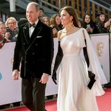 Drama-Queen! Bei der Bafta-Verleihung im Februar 2023 zeigten sich William und Kate, seit dem Tod der Queen Prinz und Prinzessin von Wales, von ihrer glamourösesten Seite. Er trug ein schickes Samt-Sakko mit Fliege, sie ein Alexander-McQueen-Kleid mit Statement-Ohrringen von Zara und langen Handschuhen. 2019 trug Kate das weiße Plissee-Outfit schon einmal, trotzdem wirkte es vier Jahre später wie neu. Die Designer hatten die Blütenapplikation an der linken Schulter durch eine große Schleife ersetzt. Passend zu den goldenen Ohrringen kombinierte sie die goldenen Aquazzura-Pumps, die sie 2021 zu ihrem "Goldfinger"-Outfit trug. Die Celeste-Clutch von Jimmy Choo besitzt Kate in mehreren Farben, die schwarze Samtausfertigung hat sie schon bei diversen Anlässen gezeigt.