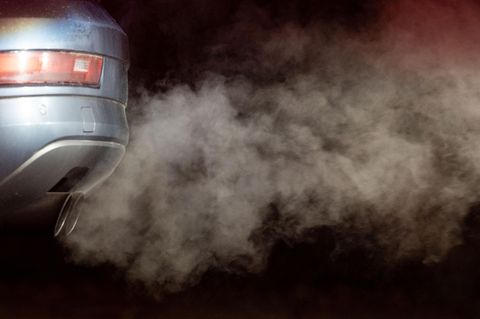 Abgase kommen aus dem Auspuff eines Autos und werden in der kalten Morgenluft sichtbar
