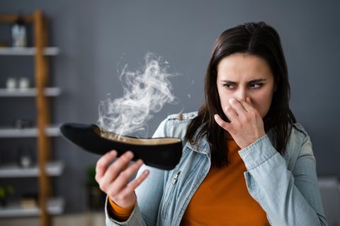 Eine Frau hält ihre Nase zu, weil hre Schuhe stinken