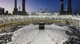 Mekka, Saudi-Arabien. Muslime haben sich am Ende des ersten Tages des Fastenmonats Ramadan um die Kaaba versammelt, um zu beten. Das quaderförmige Gebäude im Innenhof der al-Harām-Moschee ist das zentrale Heiligtum des Islams. Einmal im Jahr pilgern gläubige Moslems bei der Wallfahrt Hadsch zur Kaaba und umrunden sie siebenmal.