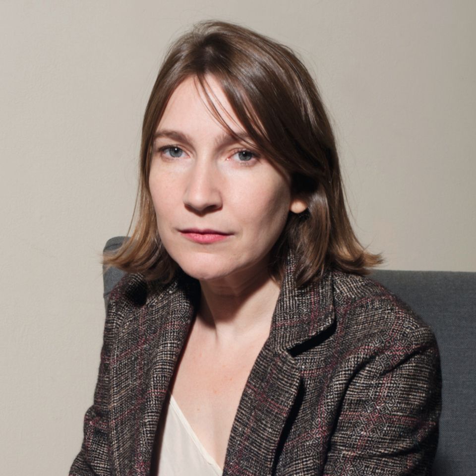 Sheila Heti sitzt auf einem Sofa und schaut in die Kamera