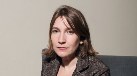 Sheila Heti sitzt auf einem Sofa und schaut in die Kamera