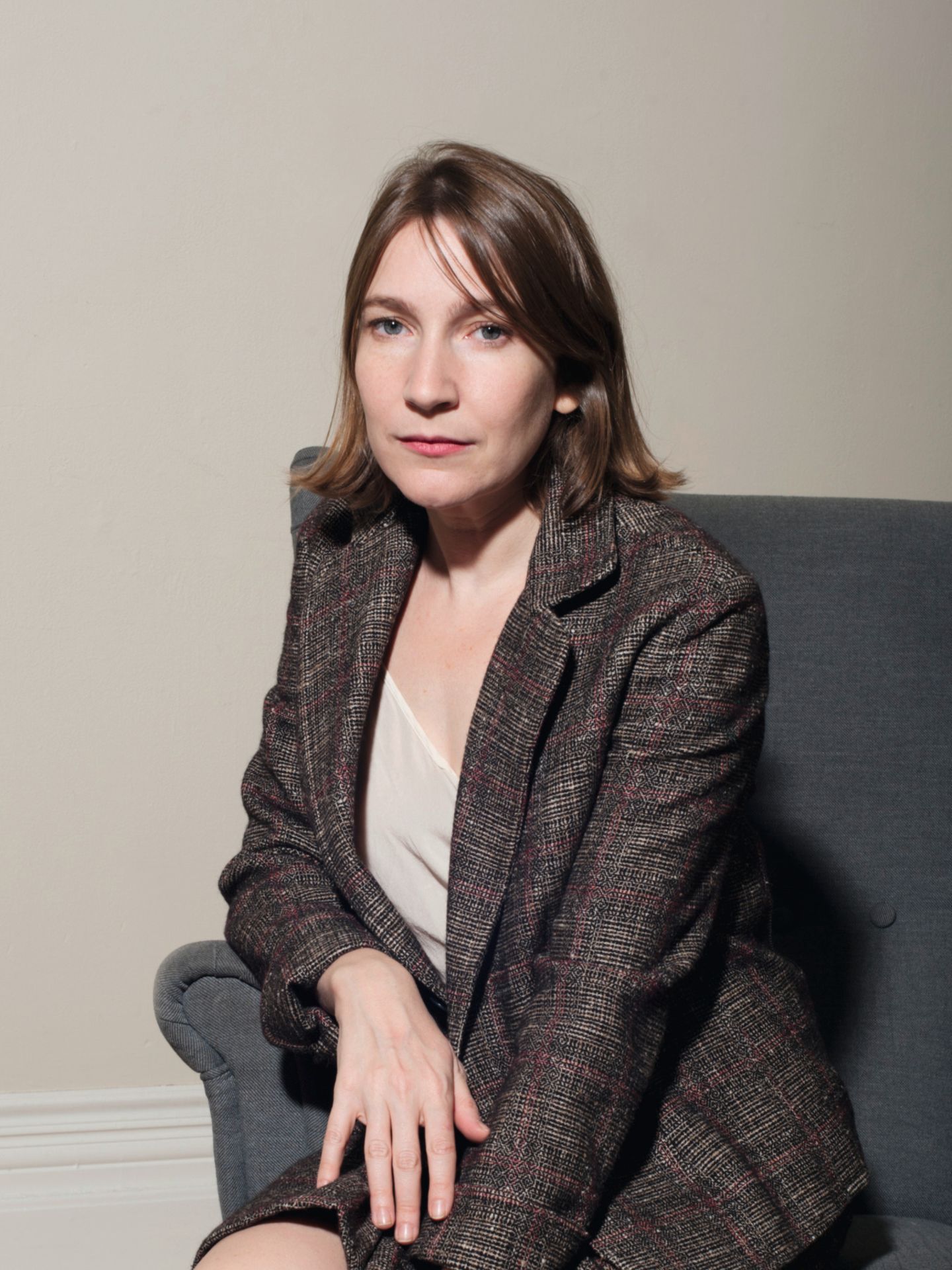 Sheila Heti Sheila Heti sitzt auf einem Sofa und schaut in die Kamera