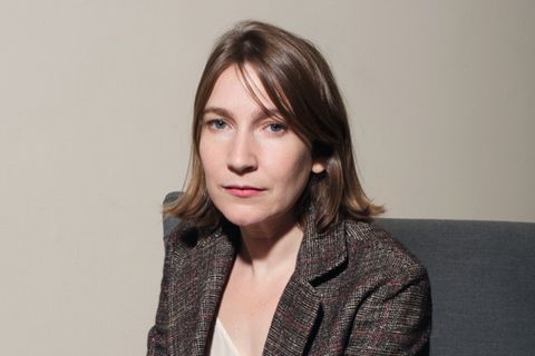 Sheila Heti sitzt auf einem Sofa und schaut in die Kamera