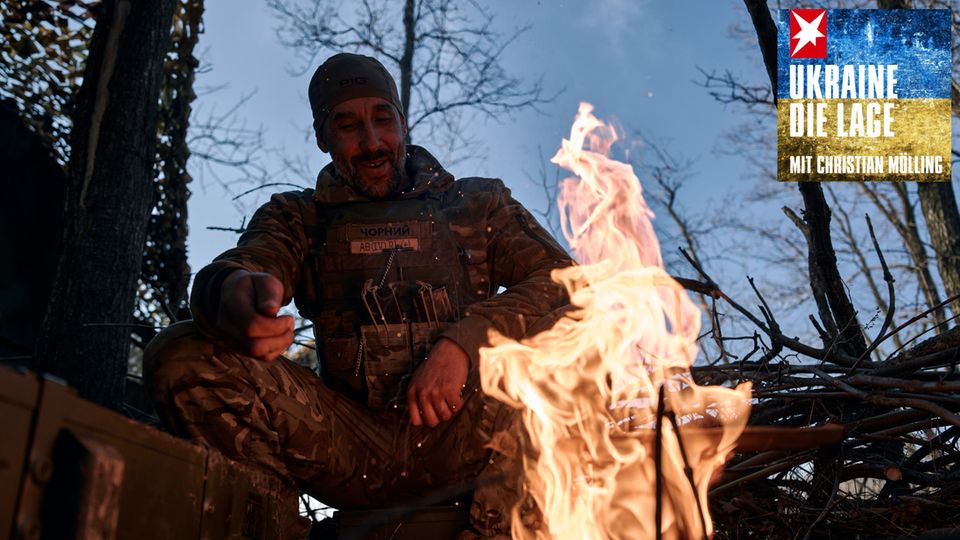 Ein ukrainischer Soldat ruht sich an der Frontlinie in der Region Donezk an einem Feuer aus
