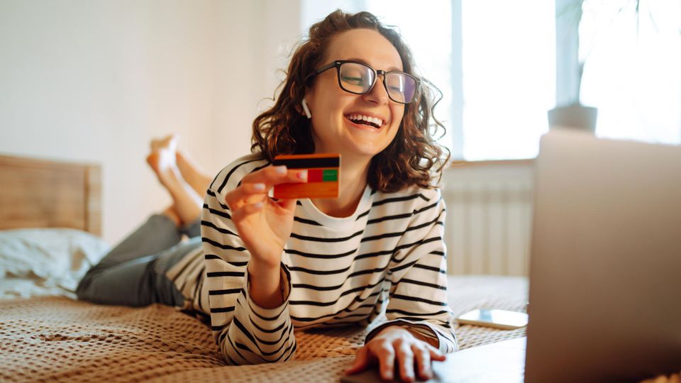 Junge Frau beim Online Shopping mit Kreditkarte