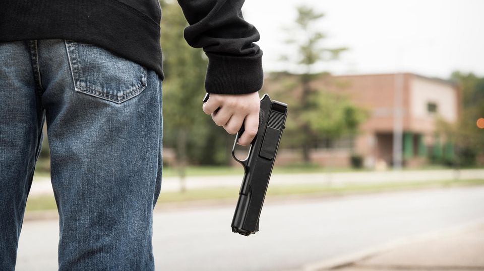 Mann hält eine Waffe in der Hand