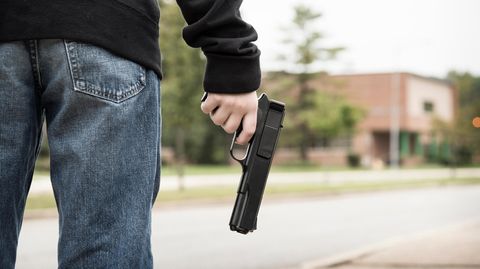 Mann hält eine Waffe in der Hand