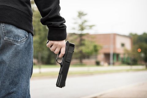 Mann hält eine Waffe in der Hand