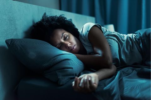 Eine Frau liegt im Bett und schläft.
